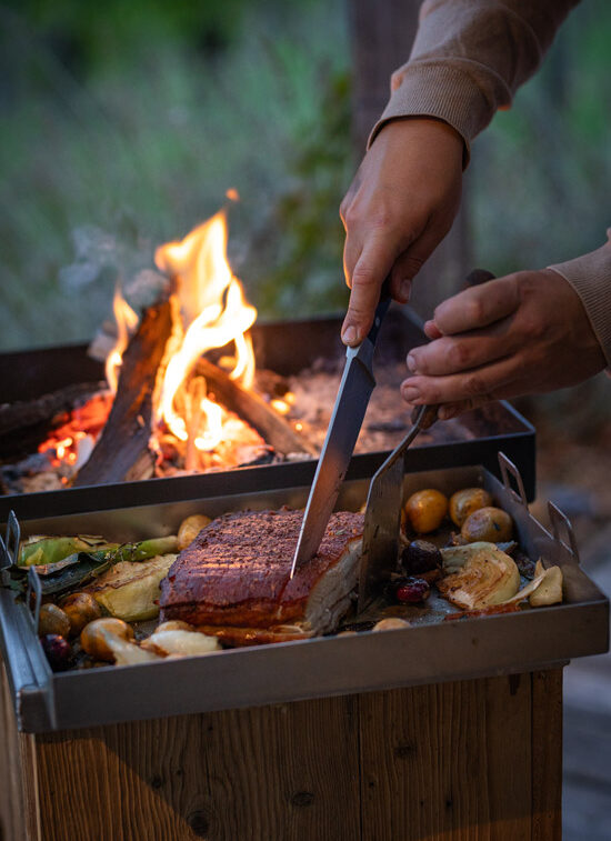 Urleben_Catering_Zubereitung eines Schweinsbratens auf der Feuerbox